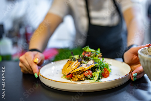 Chef cooking Caesar salad on restaurant kitchen