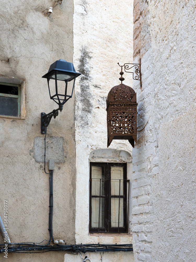 Poster Print Typical street lamp in a small street of white houses that contrasts with an old wooden street lamp 30x40 cm