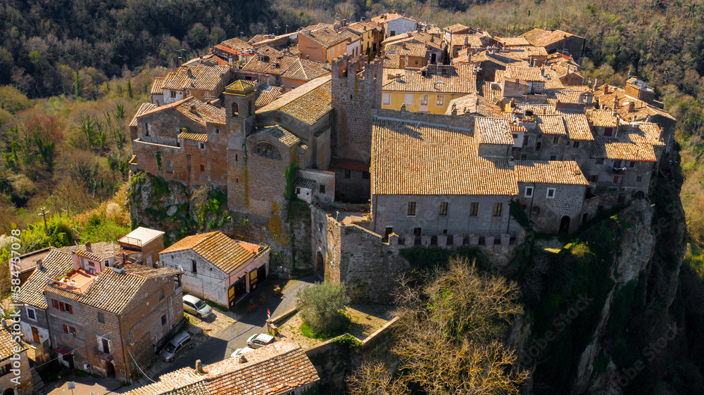 Aerial view of old town of Calcata, in the Province of Viterbo, Lazio, Italy. The town overlooking the valley of Treja. All houses have traditional red tiled roofs in the historical centre of Calcata.