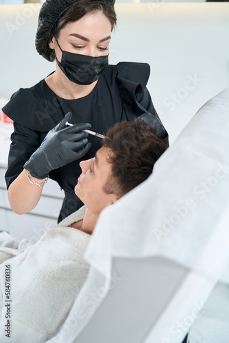 Man in beauty clinic getting hair injection procedures
