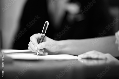 Foto in  b/n di una mano che firma un documento 