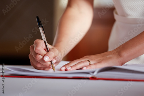 dettaglio di una mano che firma un documento  photo