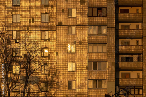 Old multi storey houses tiled by glazed tiles which looks like golden tiles under sunset lighting. Kyiv, Ukraine.