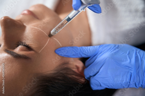 Lady doing face beauty injections in salon