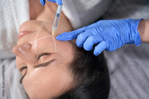 Cosmetologist doing face beauty injections in salon