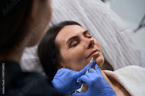 Female doing anti-aging injections to beautiful client in salon