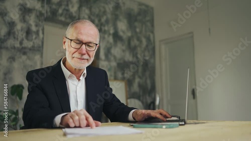Focused business man working with laptop and documents. Entrepreneur in office photo