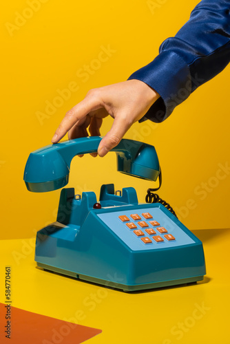 Person hanging up phone on yellow background photo