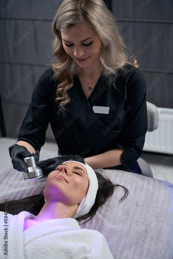 Lady doing body skin rejuvenation, working in salon Lady doing body skin rejuvenation, working in salon