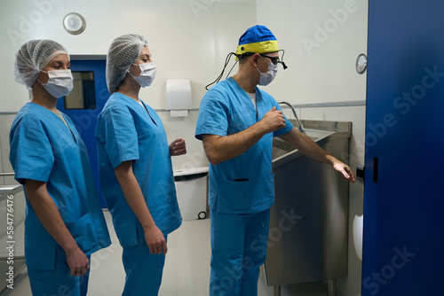 Surgeon and his assistants do sanitization of hands before operation