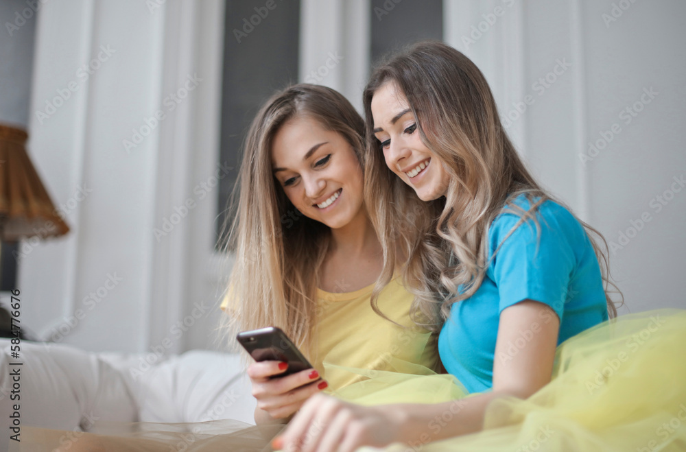 two young women use a smartphone two young women use a smartphone