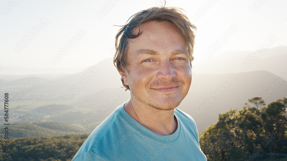Naklejka premium Portrait of the young happy smiling man. Young caucasian man outdoor at sunrise