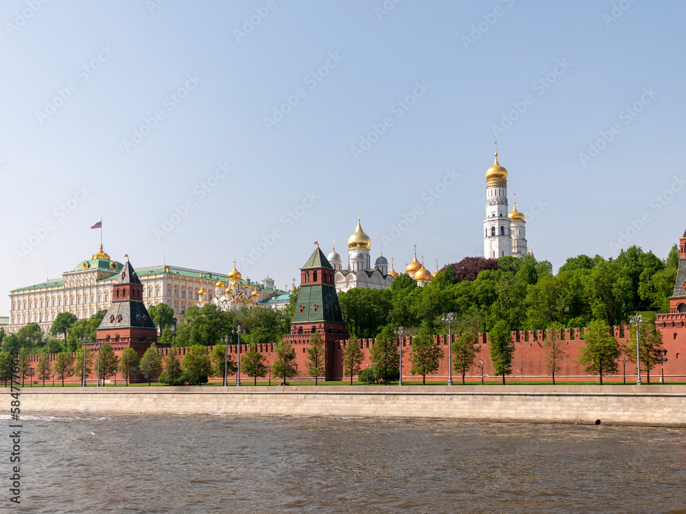 MOSCOW, RUSSIA - MAY 22, 2022: View of the Moscow Kremlin from the Moscow river. Red brick towers and Bell Tower Of Ivan The Great