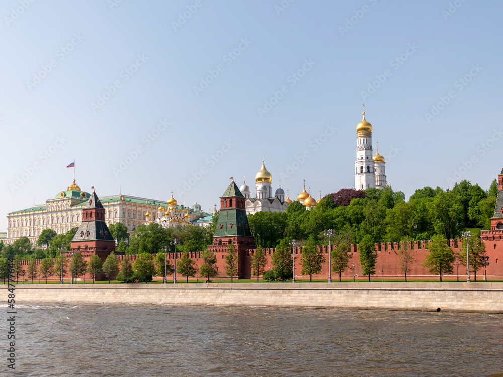 Fototapeta premium MOSCOW, RUSSIA - MAY 22, 2022: View of the Moscow Kremlin from the Moscow river. Red brick towers and Bell Tower Of Ivan The Great