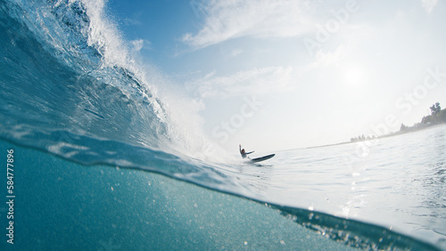 Girl surfer rides the wave. Woman surfs the ocean wave in the Maldives and falls