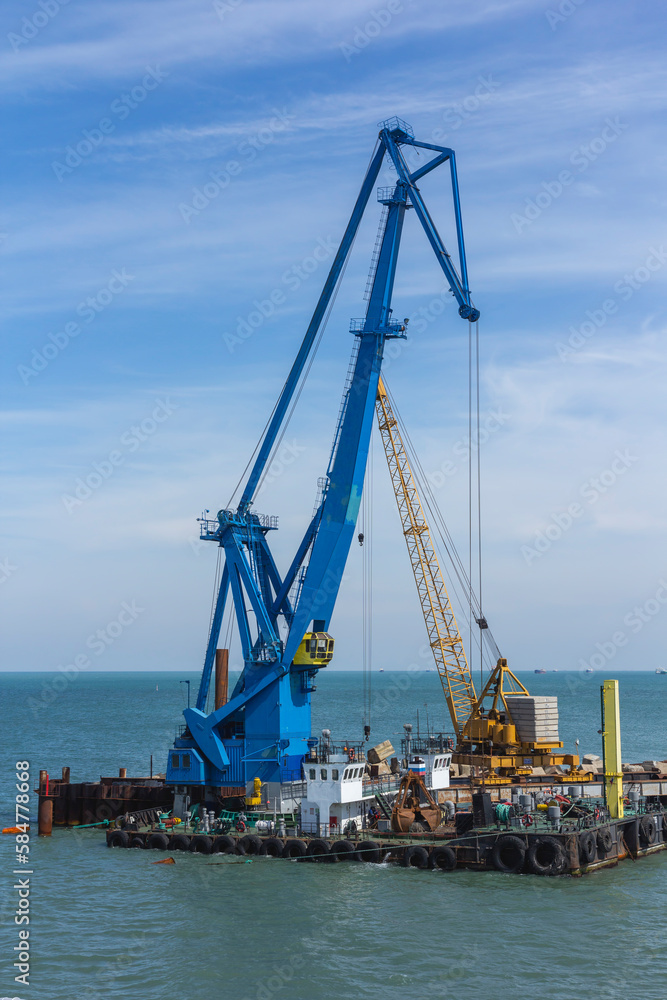 Construction work at the port dock crane in the bay of the sea