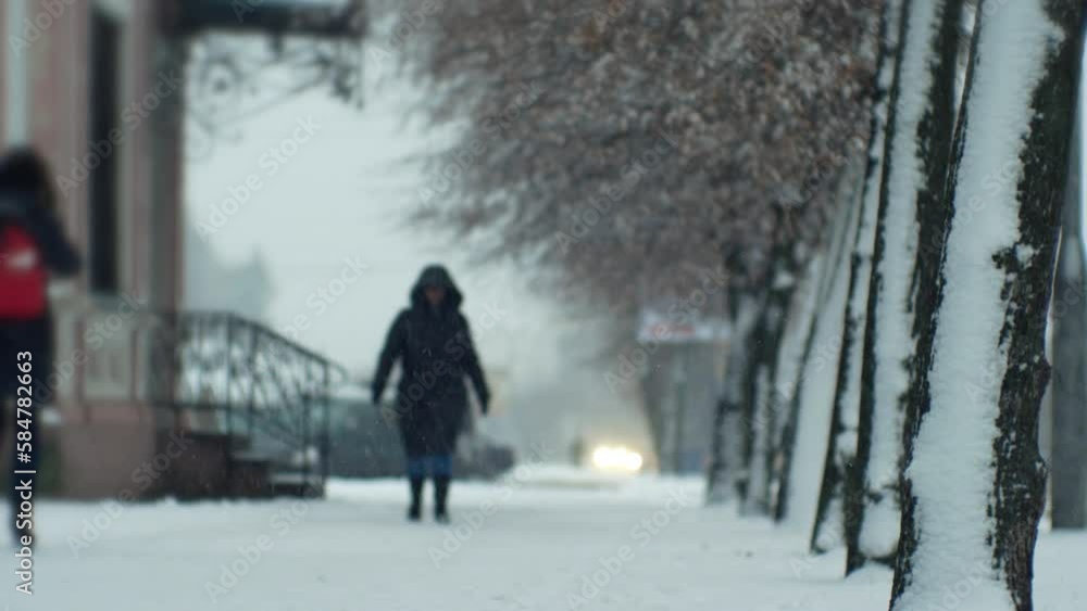 People pedestrians in a snowfall blizzard on a city street in cold winter Christmas weather People pedestrians in a snowfall blizzard on a city street in cold winter Christmas weather