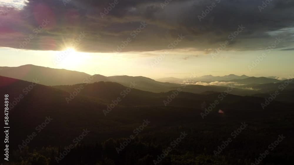Dramatic sunset in scenic landscape over mountains. 4k stock video footage of black silhouettes of mountains, orange sunset sun circle hiding behind mounts. Dramatic sunset in scenic landscape over mountains. 4k stock video footage of black silhouettes of mountains, orange sunset sun circle hiding behind mounts.