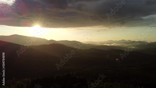Wallpaper Mural Dramatic sunset in scenic landscape over mountains. 4k stock video footage of black silhouettes of mountains, orange sunset sun circle hiding behind mounts. Torontodigital.ca