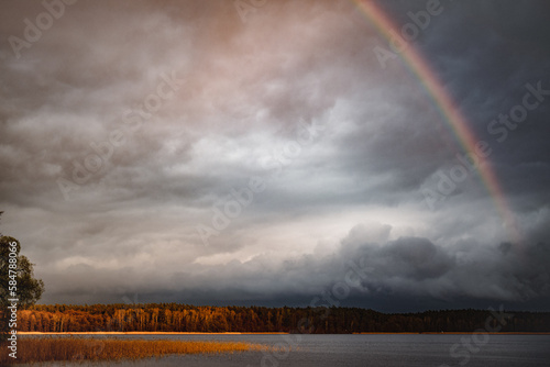 Fototapeta Naklejka Na Ścianę i Meble -  Rainbow over the storm clouds - Jeziorak Poland - Golden Hour - May - Poland - Mazurian - High quality