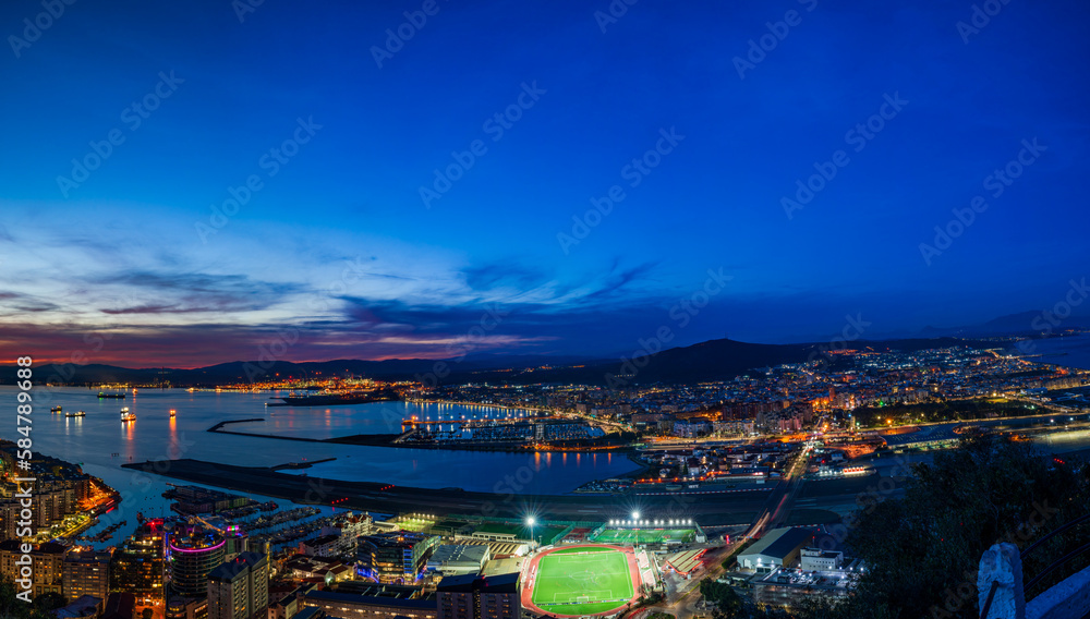 Fototapeta premium Sunset view over Gibraltar - a British Overseas Territory, and Spanish town of La Líinea de la Concepcion on Bay of Gibraltar
