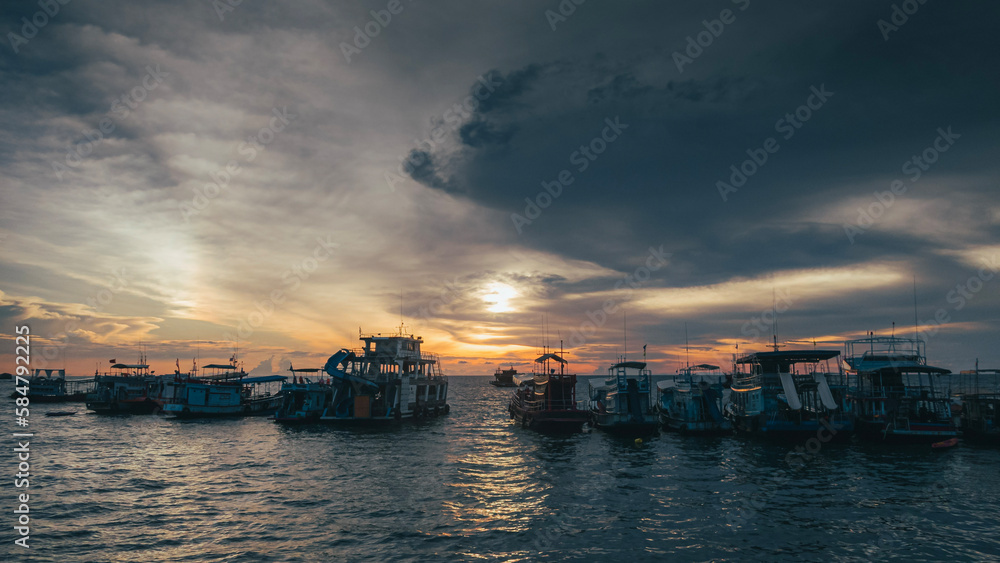 Fototapeta premium Fishing boats lined up against the blue and orange sunset on Koh Tao Thailand Island