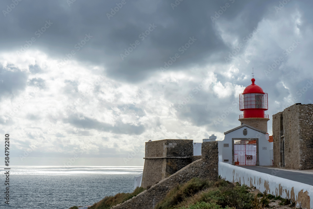 Lighthouse of Cabo de São Vicente. View of idyllic nature landscape with rocky cliff shore and waves crashing on.  Sagres, Portugal on February 27, 2023