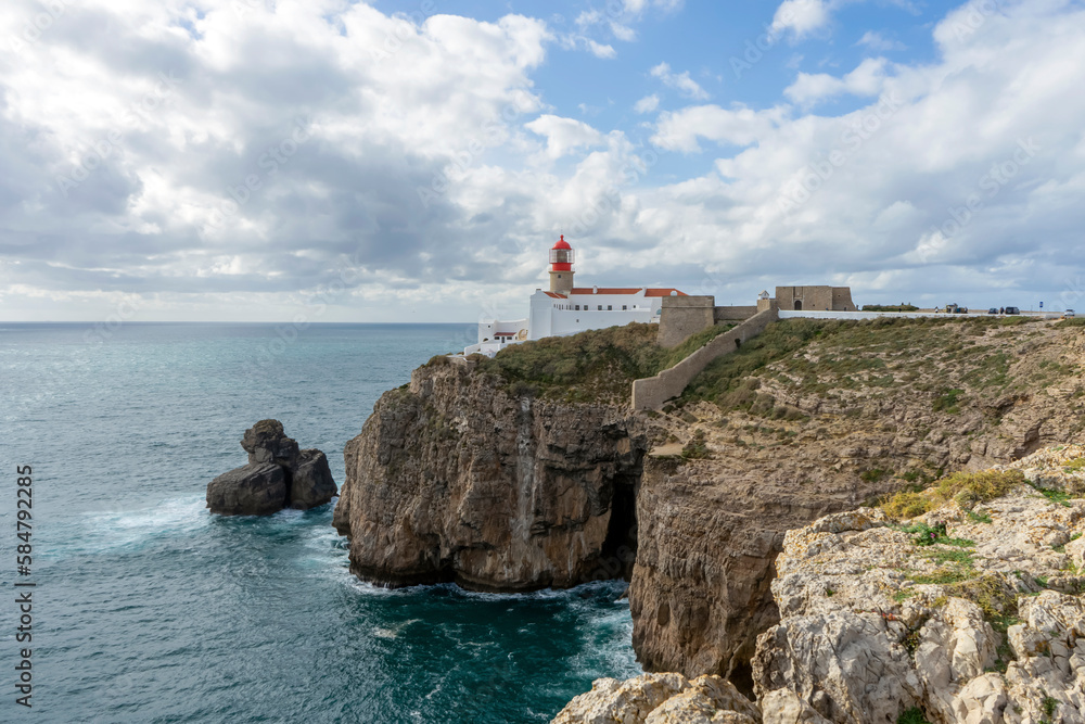 Lighthouse of Cabo de São Vicente. View of idyllic nature landscape with rocky cliff shore and waves crashing on.  Sagres, Portugal on February 27, 2023