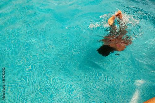 Persona nadando en la piscina en verano.