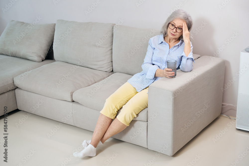 Sad gray-haired woman suffers from a headache Sad gray-haired woman suffers from a headache