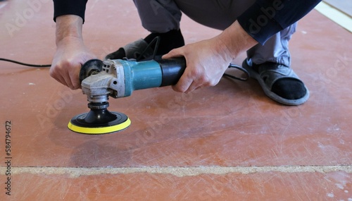 Fotografie emery yellow round nozzle on a grinder in the hands of a person in the process o