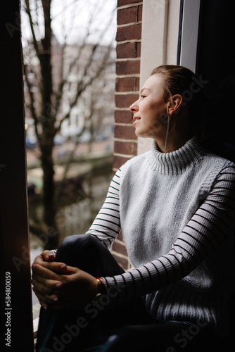 Woman relaxing and looking away  through window  photo