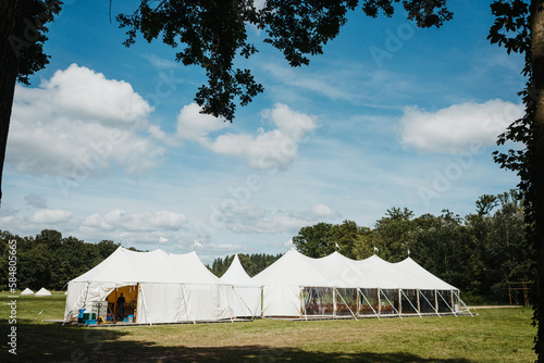 Wedding party tent on a field in between trees photo