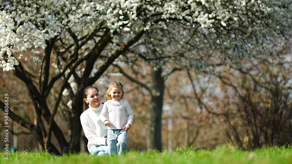 Young mother and her cute daughter having a fun in spring time park in Prague, Europe Young mother and her cute daughter having a fun in spring time park in Prague, Europe