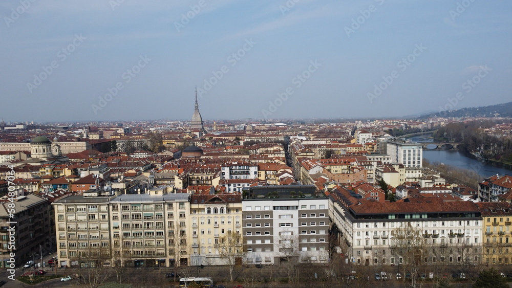 4K aerial view of cars moving along the street of the city of Turin, in the background the skyline of the city of Turin. City seen from above. Cinematic flight of the Valentino park.