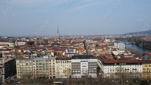 4K aerial view of cars moving along the street of the city of Turin, in the background the skyline of the city of Turin. City seen from above. Cinematic flight of the Valentino park.
