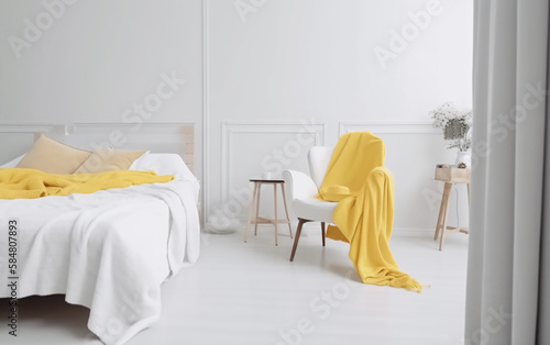 Peaceful bedroom view with a bright yellow draped chair and soft natural light. © Liana