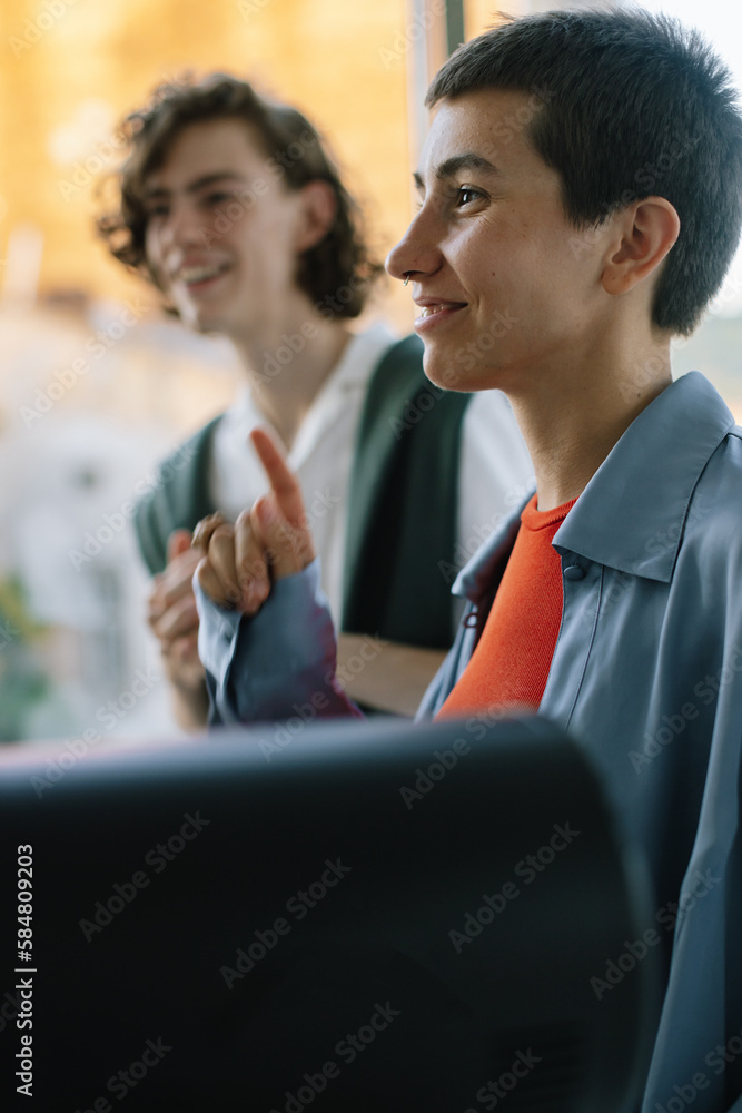 Young  Boyish Woman is Speaking at Counter Raising Her Index Finger
