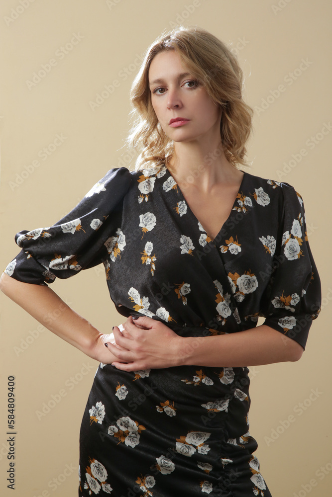 Serie of studio photos of young female model in dark floral silk satin midi dress. Serie of studio photos of young female model in dark floral silk satin midi dress.
