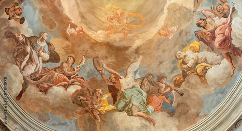 DOMODOSSOLA, ITALY - JULY 19, 2022: The fresco in baroque cupola - angels with the music instruments and the siants in the church Chiesa dei Santi Gervasio e Protasio by Lorenzo Peretti (1774 – 1851). photo