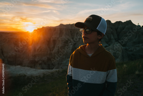 Young boy watches sunset Badlands National Park  photo