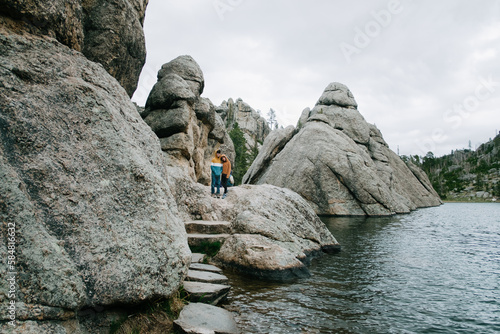 Children hiking on rocky trail near body of water photo