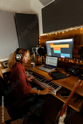 Music producer working at home studio using keyborad controller photo