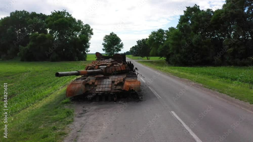 2022 - rising aerial over destroyed and abandoned Russian tank left along a road during Ukraine's summer offensive. 2022 - rising aerial over destroyed and abandoned Russian tank left along a road during Ukraine's summer offensive.