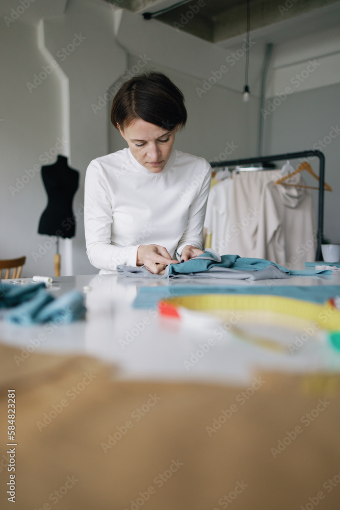 Concentrated designer. Seam. Needle. Thread. Workroom Concentrated designer. Seam. Needle. Thread. Workroom