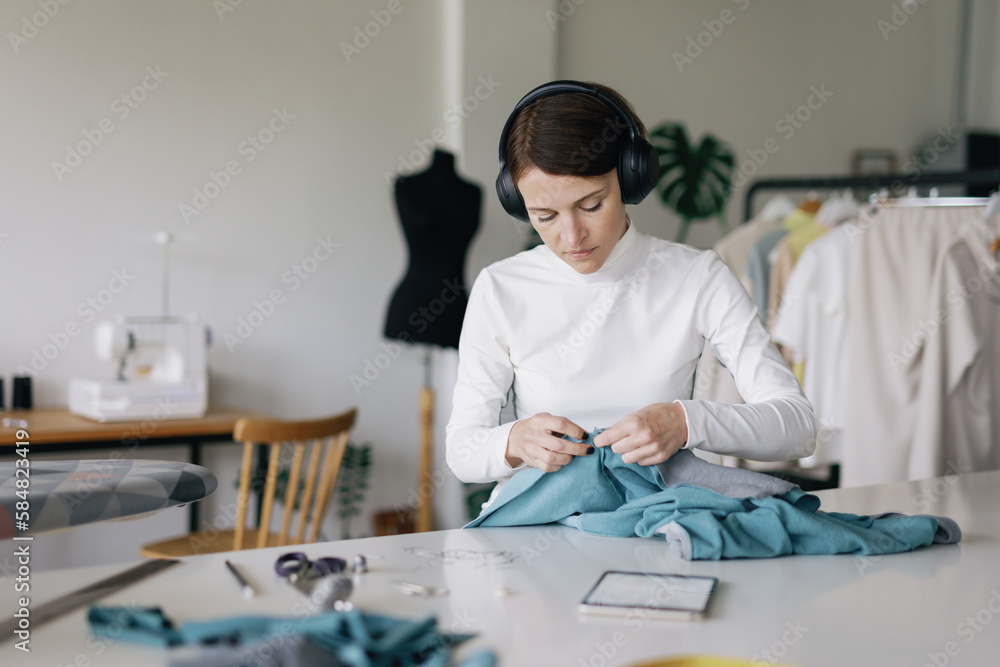 Focused at work. Headphones. Seaming apparel. Final touches. Modiste Focused at work. Headphones. Seaming apparel. Final touches. Modiste