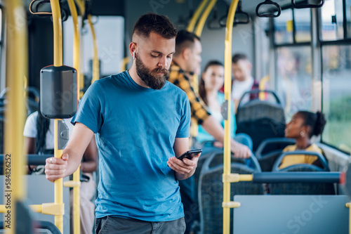Man using smartpone while riding in a bus