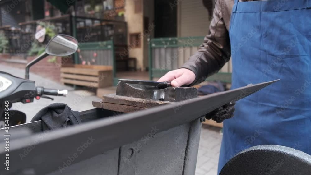man in blue apron sharpening a knife man in blue apron sharpening a knife