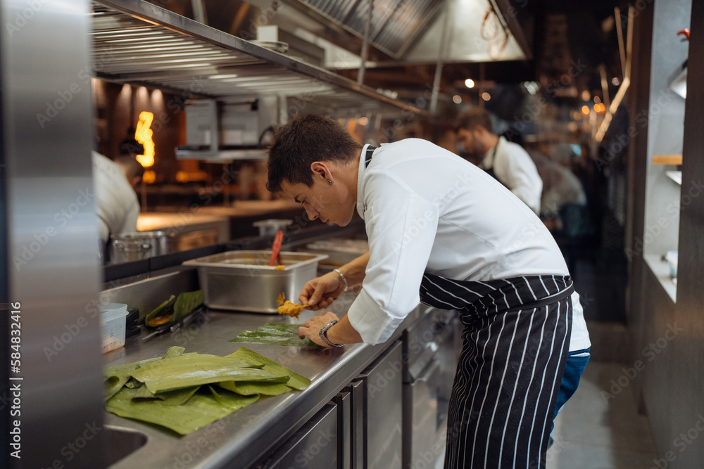 Male chef putting curry on banana leaf Male chef putting curry on banana leaf