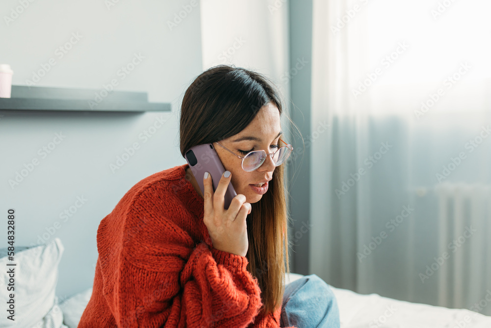 Pretty Young Woman Sitting on Bed And Talking on Phone Pretty Young Woman Sitting on Bed And Talking on Phone